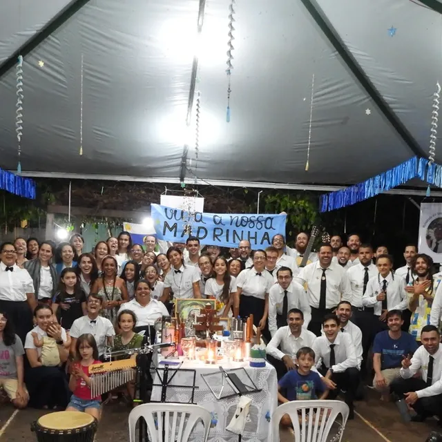 Grande celebração noturna da comunidade sob a tenda enfeitada de fitas azuis